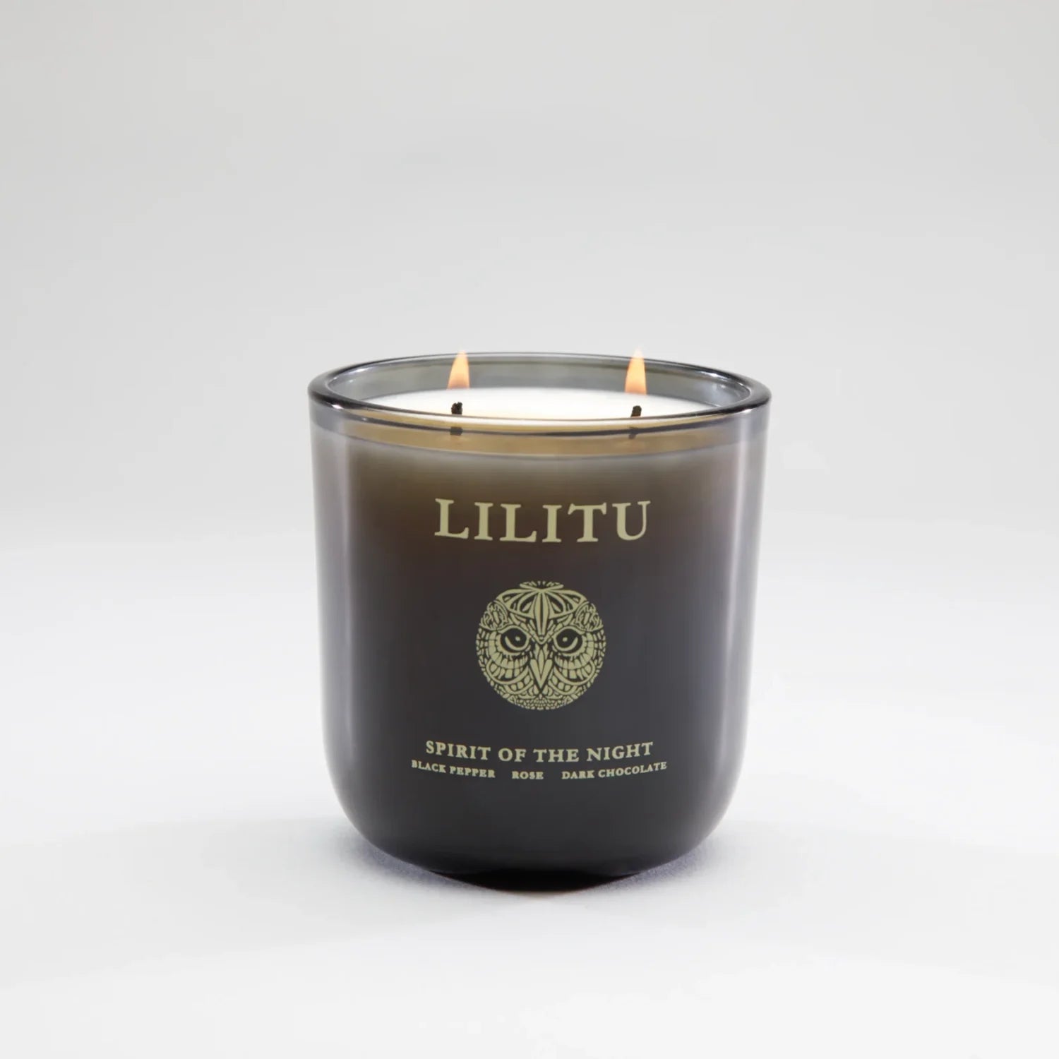 Lilitu Spirit of the Night smoked glass candle with two lit wicks